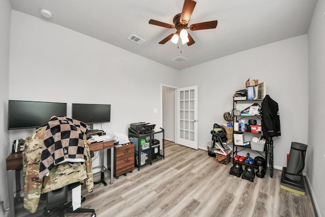 office space with baseboards, ceiling fan, wood finished floors, and visible vents