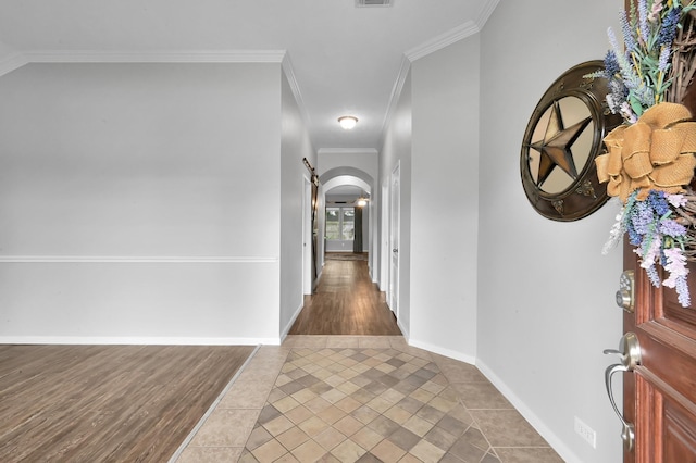 hallway with arched walkways, tile patterned floors, and ornamental molding