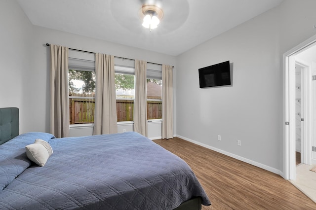 bedroom with baseboards, a ceiling fan, and wood finished floors
