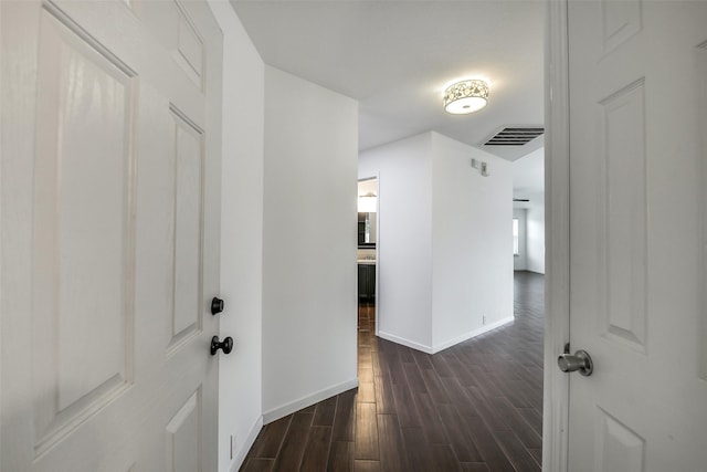 hall with baseboards, dark wood-type flooring, and visible vents