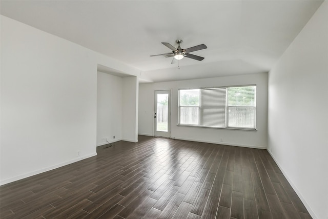 unfurnished room featuring dark wood-style flooring, ceiling fan, and baseboards