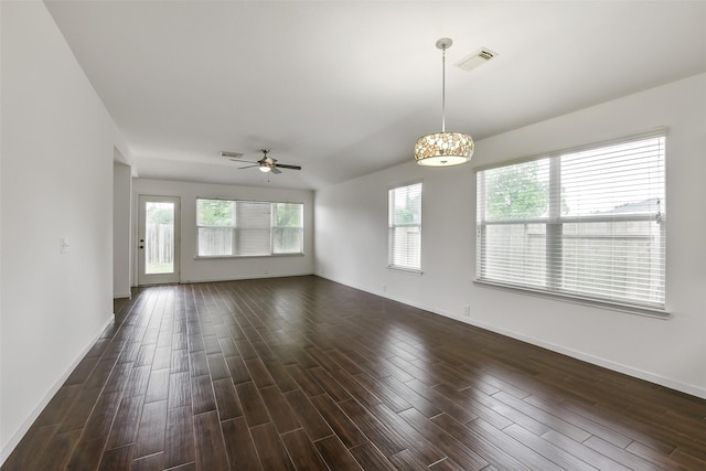 interior space featuring baseboards, a ceiling fan, dark wood-style floors, and visible vents