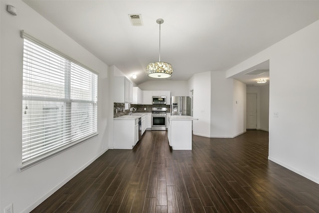 kitchen with light countertops, stainless steel appliances, dark wood finished floors, and visible vents