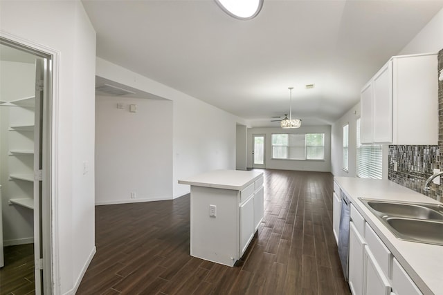 kitchen featuring a sink, white cabinets, dark wood-style floors, and open floor plan