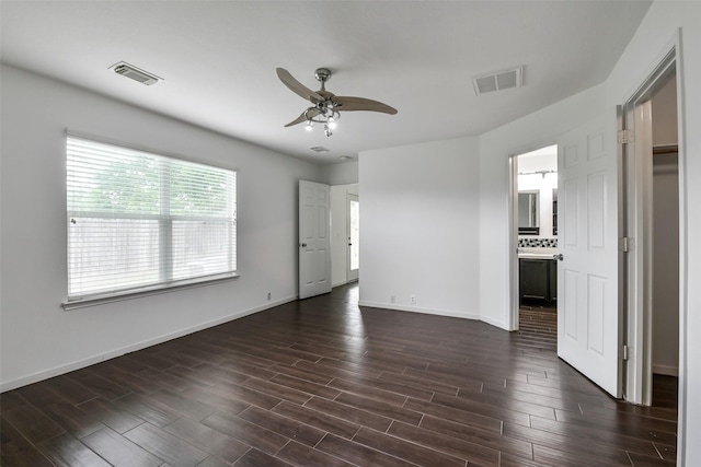 unfurnished bedroom with visible vents, dark wood finished floors, and baseboards