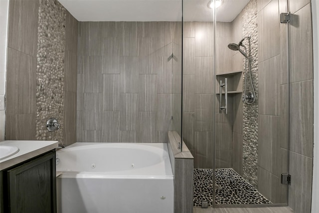bathroom featuring a tub with jets, vanity, and a shower stall