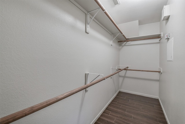 spacious closet with dark wood-style flooring and visible vents