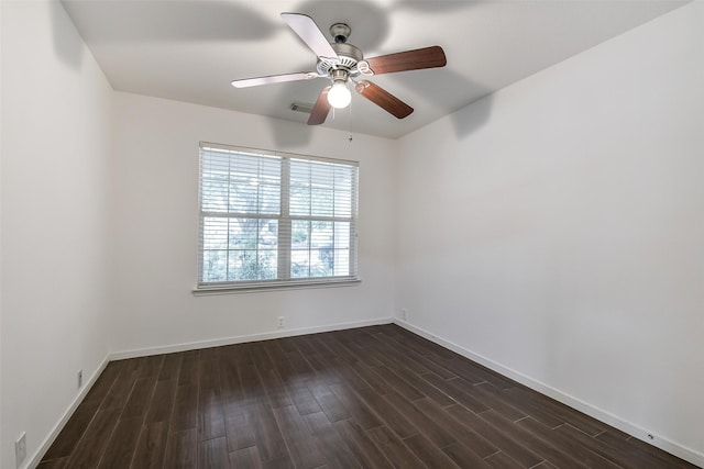 spare room with baseboards, ceiling fan, visible vents, and dark wood-type flooring