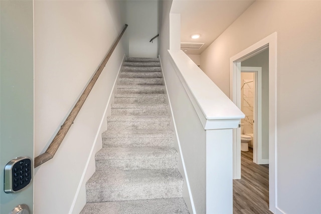 staircase with recessed lighting and wood finished floors