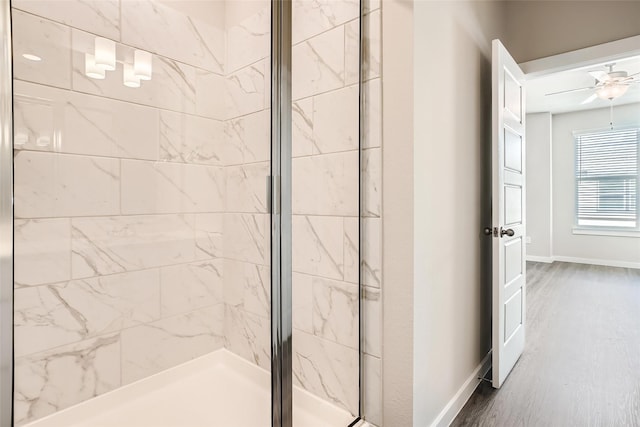full bathroom featuring baseboards, ceiling fan, and a stall shower