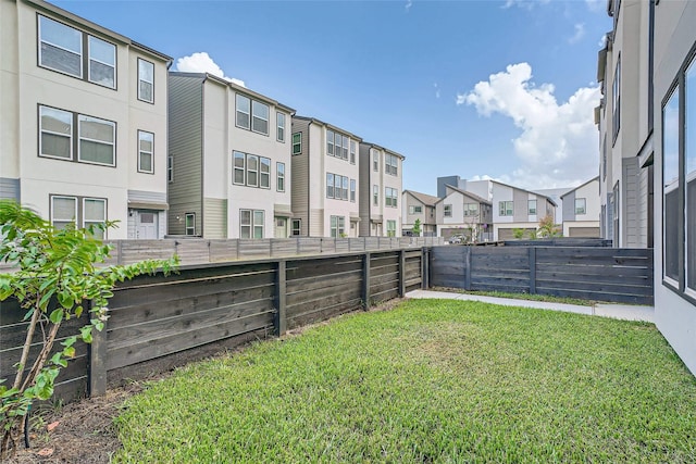 view of yard featuring a fenced backyard and a residential view
