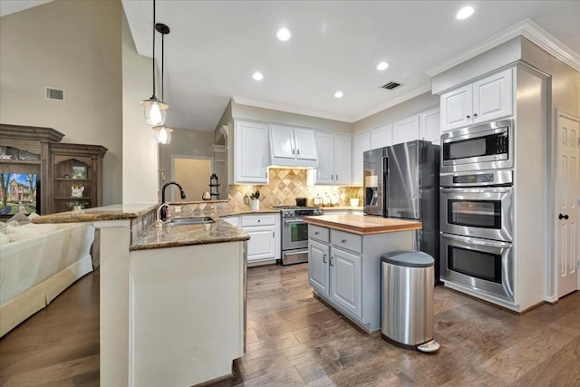 13538 Scenic Glade Dr, Houston, TX 77059 - kitchen with stainless steel appliances, wooden counters, a peninsula, crown molding, and tasteful backsplash