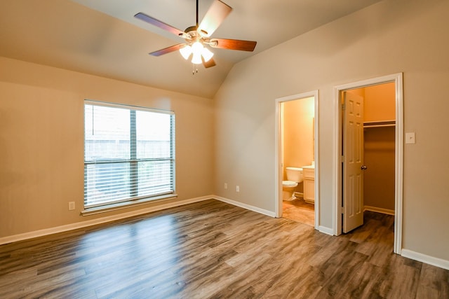 629 Pelican Harbour Dr, Texas City, TX 77590 - unfurnished bedroom featuring vaulted ceiling, a spacious closet, wood finished floors, baseboards, and connected bathroom