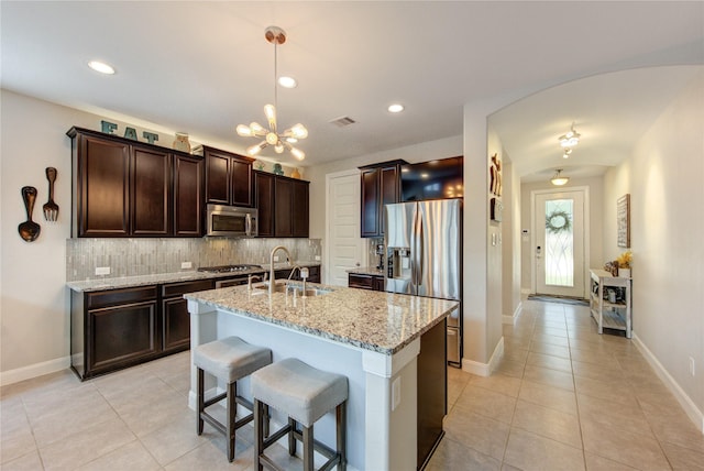 kitchen with light tile patterned floors, stainless steel appliances, a sink, and visible vents