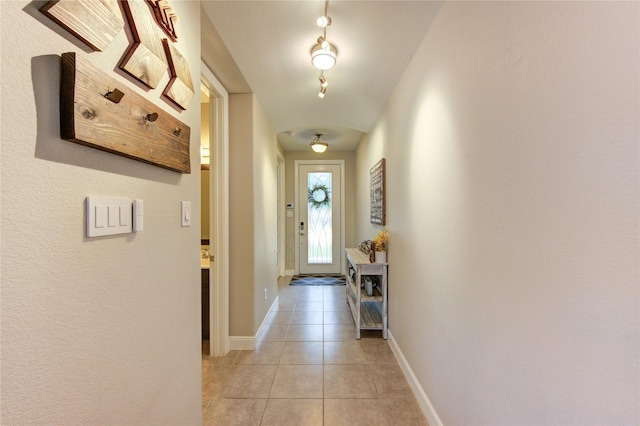 hallway with baseboards and light tile patterned flooring