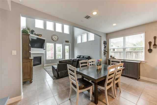 dining space featuring a tiled fireplace, recessed lighting, baseboards, light tile patterned floors, and visible vents