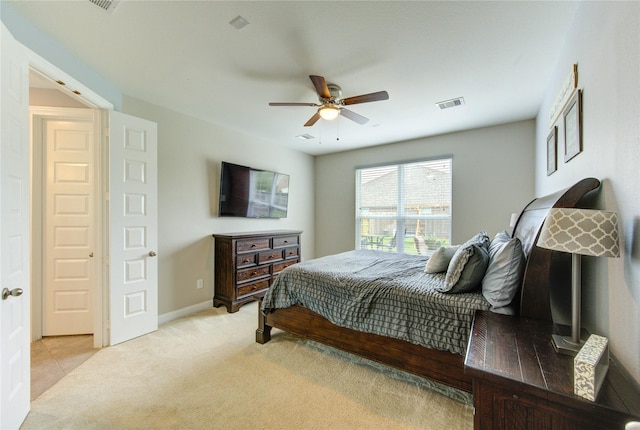 bedroom featuring visible vents, baseboards, ceiling fan, and light carpet