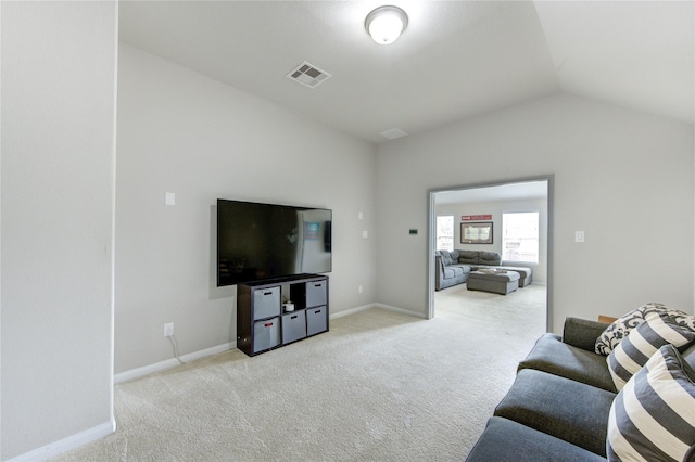 living area with baseboards, light carpet, lofted ceiling, and visible vents