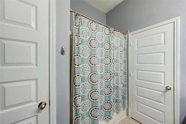 bathroom featuring tile patterned flooring and curtained shower