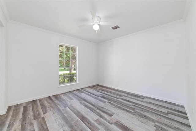 spare room featuring crown molding, a ceiling fan, wood finished floors, and visible vents