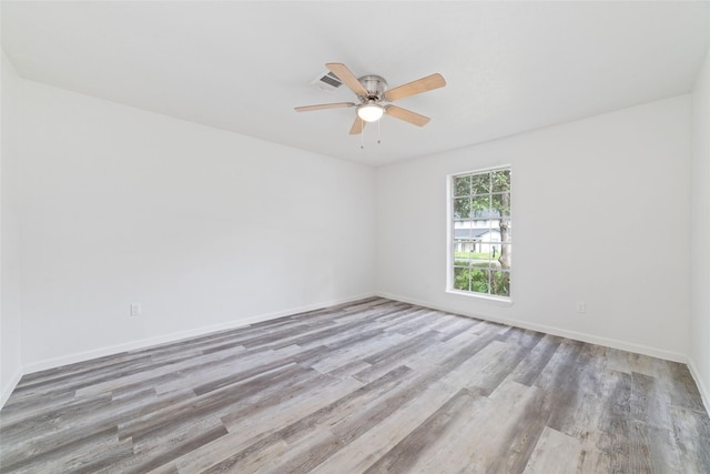 unfurnished room featuring visible vents, a ceiling fan, baseboards, and wood finished floors