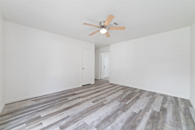 unfurnished room with baseboards, a ceiling fan, and wood finished floors