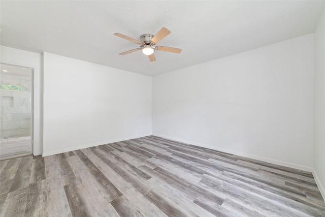spare room with a ceiling fan, baseboards, and wood finished floors