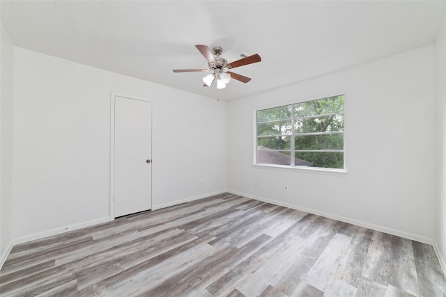 spare room with baseboards, a ceiling fan, and wood finished floors
