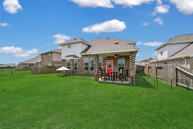 rear view of house featuring roof with shingles, a fenced backyard, a patio area, a lawn, and a ceiling fan