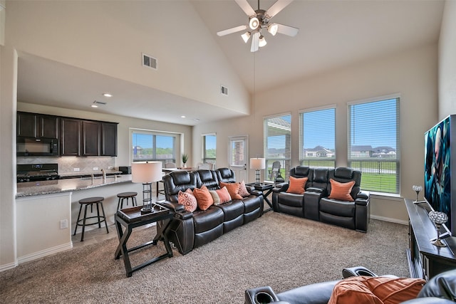 living area featuring ceiling fan, light colored carpet, and visible vents