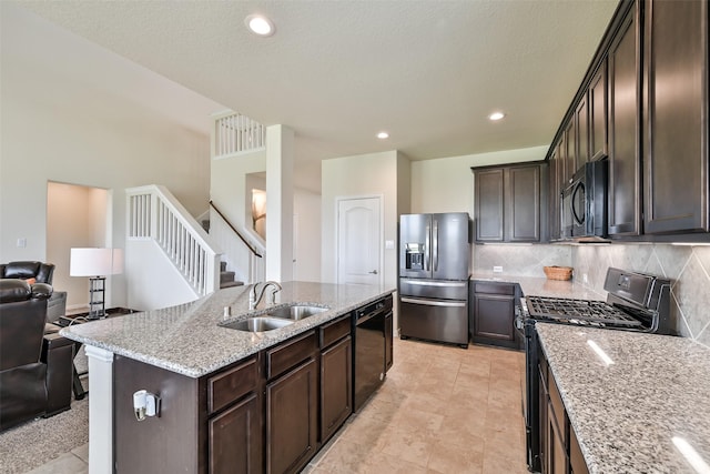 23109 Zinfandel Dr, Alvin, TX 77511 - kitchen featuring black appliances, a sink, open floor plan, decorative backsplash, and light stone countertops