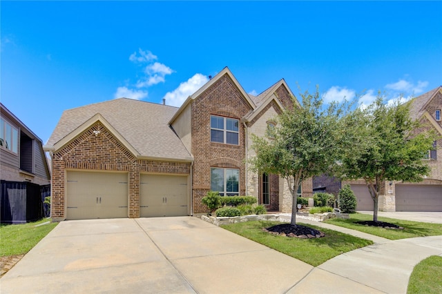 traditional-style house featuring a garage, a shingled roof, driveway, and brick siding