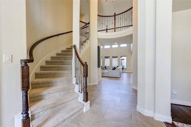 entrance foyer featuring baseboards, stairs, and a towering ceiling