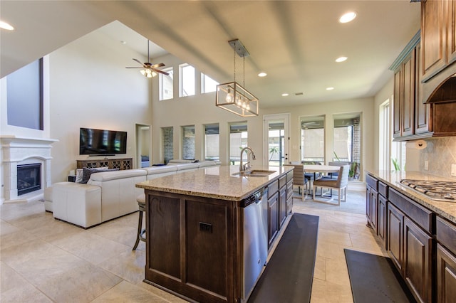 kitchen featuring a sink, stainless steel appliances, recessed lighting, and a glass covered fireplace
