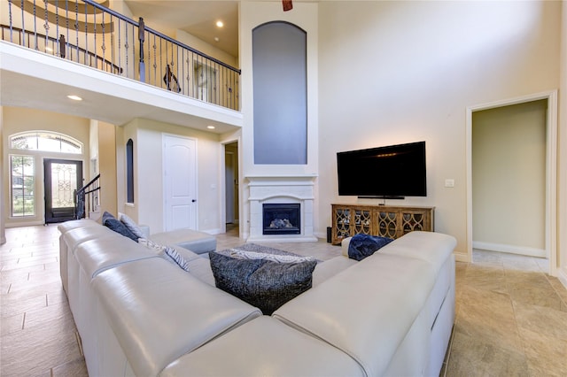 living room featuring recessed lighting, baseboards, and a towering ceiling