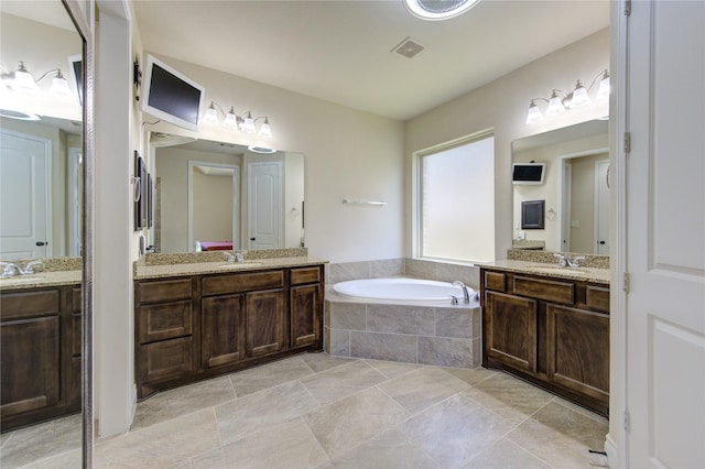 bathroom with a sink, a bath, and two vanities