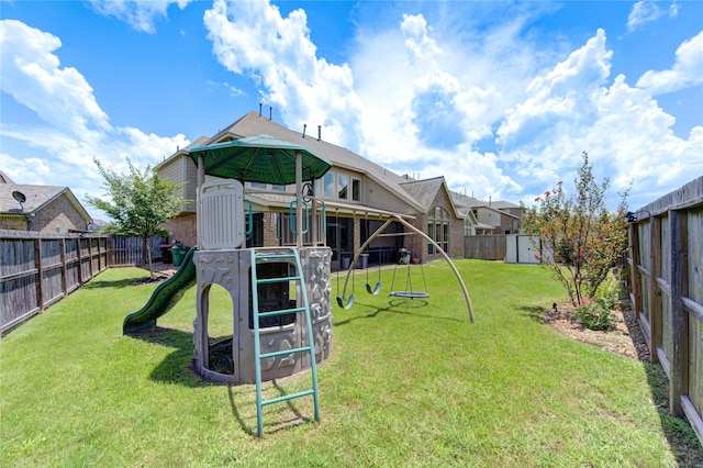 view of playground featuring a fenced backyard, a yard, and a shed
