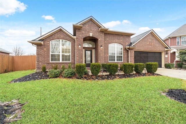view of front of house with fence, a front lawn, brick siding, a garage, and driveway