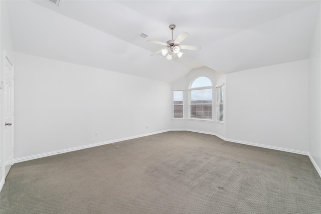 empty room with a ceiling fan, visible vents, carpet floors, baseboards, and lofted ceiling