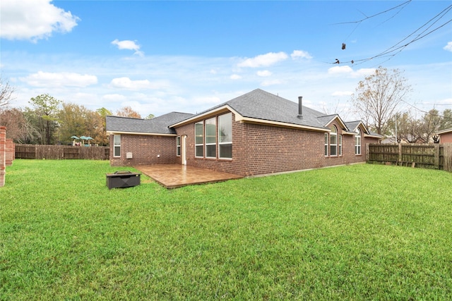 back of house featuring a fenced backyard, a lawn, and brick siding
