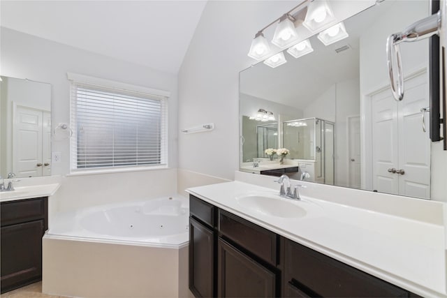 full bathroom with a sink, a shower stall, a tub with jets, and lofted ceiling