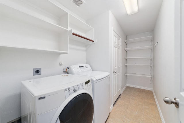 laundry room with laundry area, separate washer and dryer, baseboards, light tile patterned floors, and visible vents