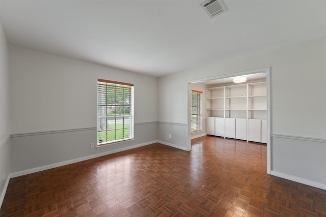 unfurnished room with baseboards and visible vents