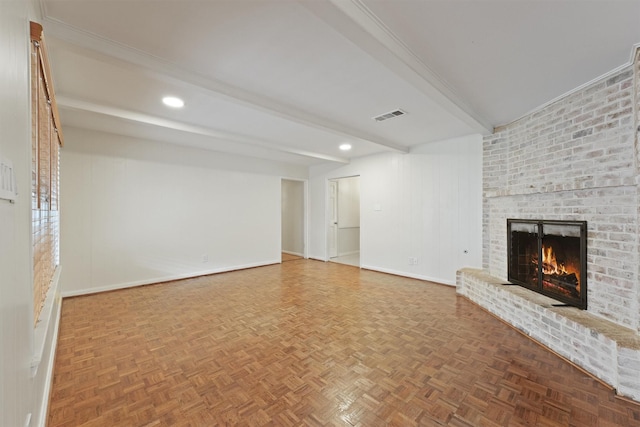 unfurnished living room with baseboards, beamed ceiling, a brick fireplace, and visible vents
