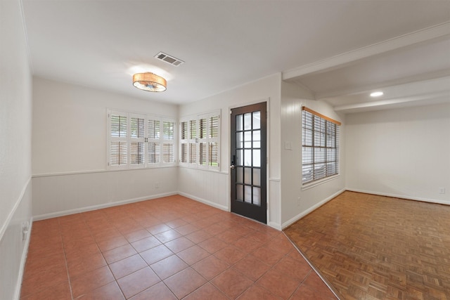 spare room featuring baseboards, visible vents, and a wealth of natural light