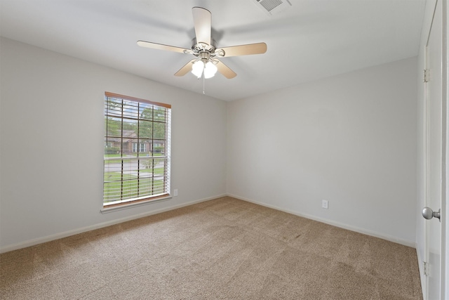 carpeted spare room featuring baseboards, a ceiling fan, and visible vents