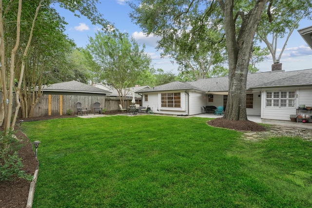 rear view of property with a patio, a lawn, and fence