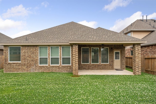 back of property featuring a fenced backyard, a patio area, roof with shingles, and brick siding