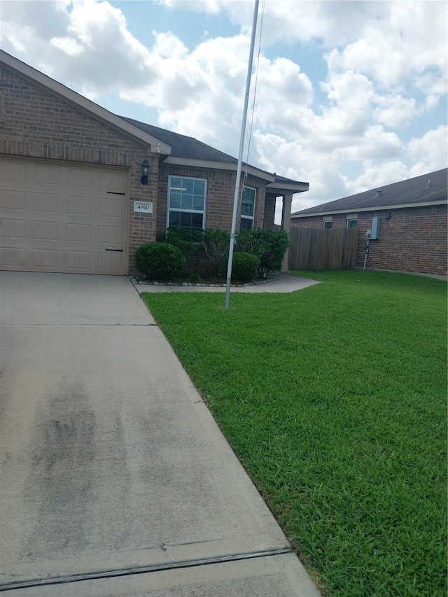 ranch-style home featuring fence, a front lawn, brick siding, a garage, and concrete driveway