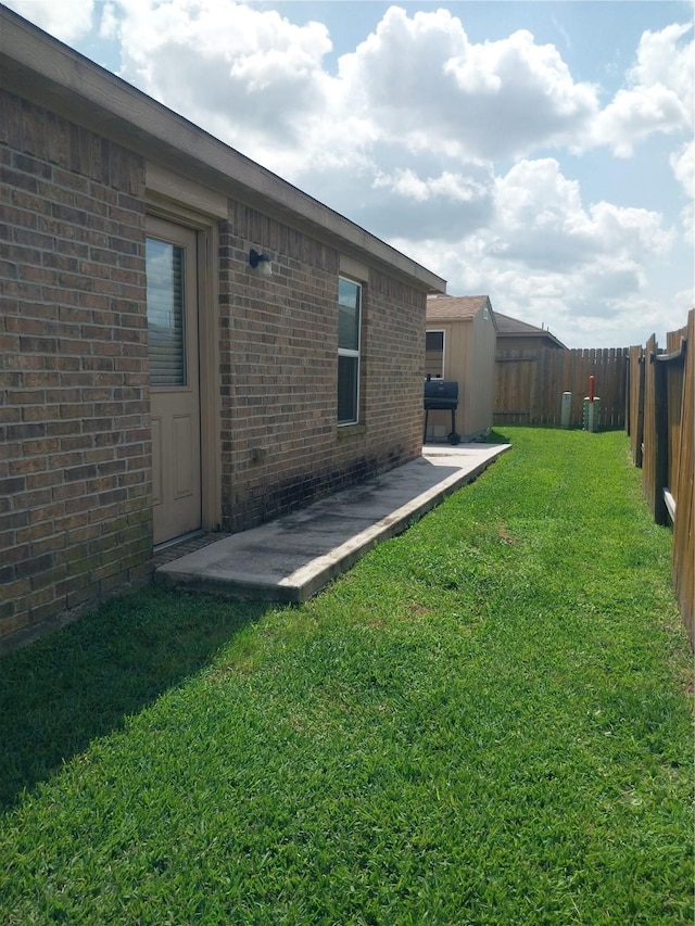 view of yard featuring a fenced backyard, an outdoor structure, and a storage shed